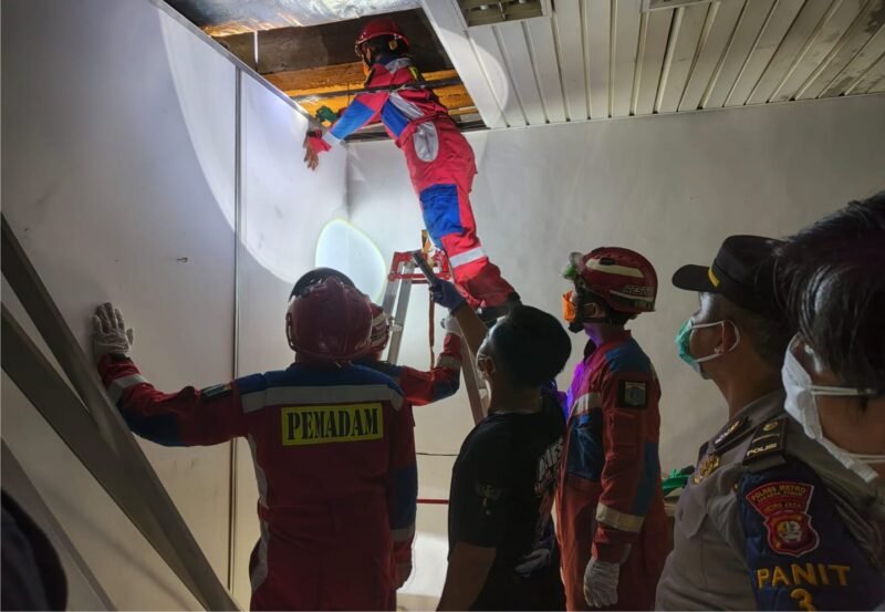 Petugas Pemadam Kebakaran evakuasi mayat dalam flapon Gudang Pabrik di kawasan industri Pulomas, Jakarta Timur
