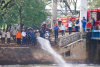 Petugas DLH DKI Jakarta menyemprot busa putih di Pintu Weir 3 Kanal Banjir Timur menggunakan mikroba pengurai pencemar, Rabu (13/8/2025). (Dok-Humas DKI Jakarta)

