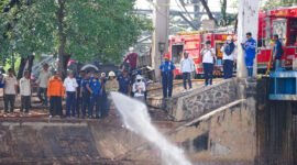 Petugas DLH DKI Jakarta menyemprot busa putih di Pintu Weir 3 Kanal Banjir Timur menggunakan mikroba pengurai pencemar, Rabu (13/8/2025). (Dok-Humas DKI Jakarta)
