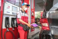 Petugas SPBU melakukan aktifitas pengisian BBM