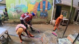 Personel Ditpolairud Polda Metro Jaya membantu warga Kampung Pulo bersihkan rumah dan saluran air usai banjir, Selasa (5/8/2025).