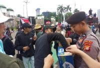 Personel Samapta Polda Metro Jaya membagikan air mineral dan roti kepada peserta aksi buruh di depan Gedung DPR/MPR RI, Jakarta, Kamis (28/8/2025). Aksi simpatik ini menjadi wujud pelayanan humanis Polri kepada masyarakat. Dok-Polri