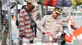 Kapolres Metro Jakarta Barat Kombes Pol Twedi Aditya Bennyahdi membagikan Bendera Merah Putih kepada pengendara di Jalan Tomang Raya dalam rangka menyambut HUT ke-80 RI, Kamis (7/8/2025). (Dok-Istimewa)