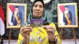 Penerima manfaat Bansos KAJ, KLJ, dan KPDJ menunjukkan kartu ATM bantuan di Jakarta. Dok: Kominfo DKI JKT