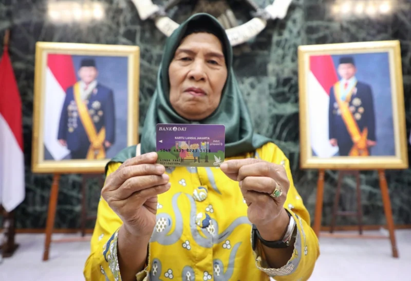 Penerima manfaat Bansos KAJ, KLJ, dan KPDJ menunjukkan kartu ATM bantuan di Jakarta. Dok: Kominfo DKI JKT