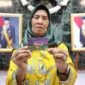 Penerima manfaat Bansos KAJ, KLJ, dan KPDJ menunjukkan kartu ATM bantuan di Jakarta. Dok: Kominfo DKI JKT