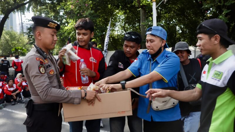 Anggota Polri memberikan air mineral dan roti kepada peserta unjuk rasa di kawasan Monas, Gambir, Rabu (10/9/2025) sore. Dok-Polri
