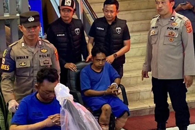 Petugas kepolisian menunjukkan dua pelaku pembunuh keluarga Haji Sahroni di Paoman, Indramayu. Dok-Polda Jabar.