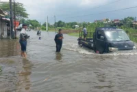 Warga Semarang berjalan di tengah genangan banjir setinggi lutut di kawasan Pedurungan, Jawa Tengah. Dok: BNPB