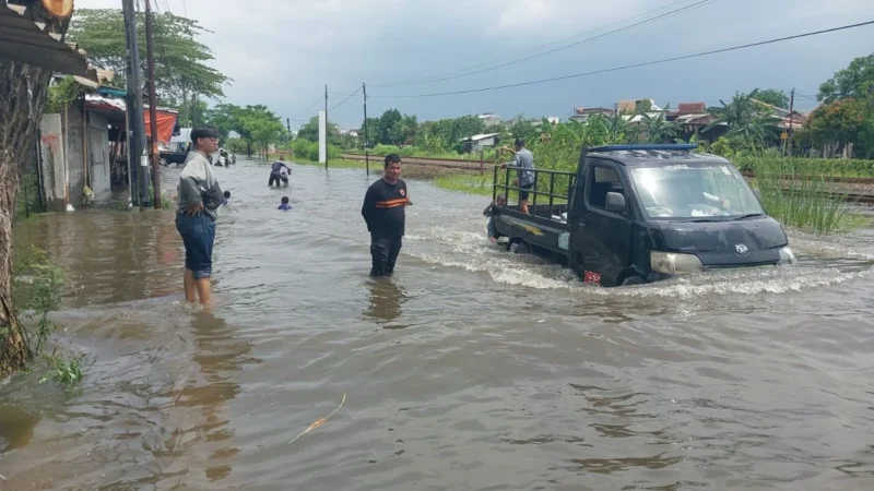 Warga Semarang berjalan di tengah genangan banjir setinggi lutut di kawasan Pedurungan, Jawa Tengah. Dok: BNPB