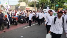 Guru mengenakan ikat kepala putih berjalan kaki menuju Monas saat aksi unjuk rasa di Jakarta Pusat, Kamis 30 Oktober 2025. (TMC PMJ)