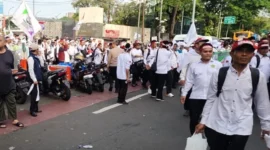 Guru mengenakan ikat kepala putih berjalan kaki menuju Monas saat aksi unjuk rasa di Jakarta Pusat, Kamis 30 Oktober 2025. (TMC PMJ)