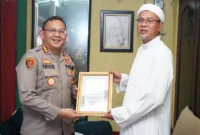 Kapolres Metro Jakarta Utara Kombes Pol Erick Frendriz menyerahkan piagam penghargaan kepada Habib Fatih Al-Habsyi di Kelapa Gading Timur, sebagai apresiasi atas dukungan menjaga keamanan dan ketertiban masyarakat. Dok: Polri