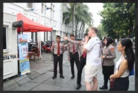 Petugas memberikan informasi kepada wisatawan luar terkait program “Lapor Aman Kota Tua”. Dok: PMJ