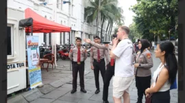 Petugas memberikan informasi kepada wisatawan luar terkait program “Lapor Aman Kota Tua”. Dok: PMJ