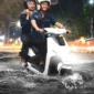 Ilustrasi, Pengendara motor listrik terobos banjir. (Ist)
