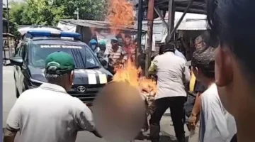 Terduga pencuri motor terbakar usai diamuk massa di Gubeng Surabaya, polisi memadamkan api dan mengevakuasi ke RS Bhayangkara. (Ist)