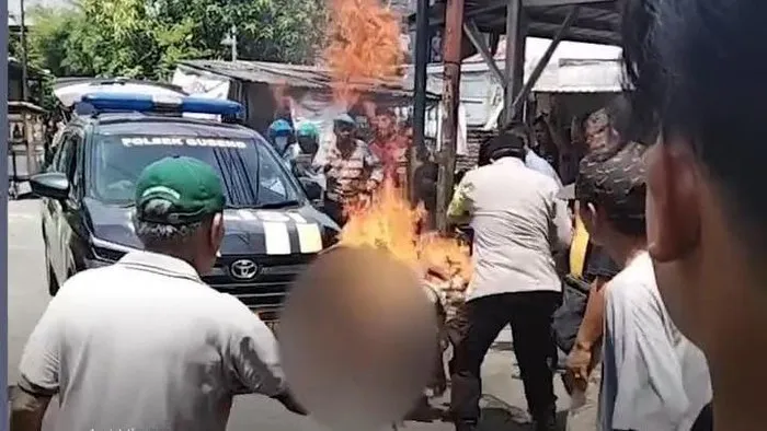 Terduga pencuri motor terbakar usai diamuk massa di Gubeng Surabaya, polisi memadamkan api dan mengevakuasi ke RS Bhayangkara. (Ist)