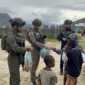 Personel Satgas Operasi Damai Cartenz Paniai membagikan sembako dan makanan ringan kepada warga di Jalan Modern, Enarotali, Papua. Dok: Polri