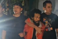 Pelaku penembakan pengacara di Tanah Abang, HD (37), saat dibekuk Tim Jatanras Polda Metro Jaya dan digiring ke mobil polisi. (PMJ)