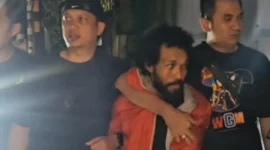 Pelaku penembakan pengacara di Tanah Abang, HD (37), saat dibekuk Tim Jatanras Polda Metro Jaya dan digiring ke mobil polisi. (PMJ)