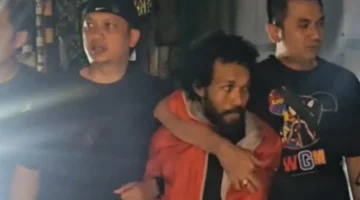 Pelaku penembakan pengacara di Tanah Abang, HD (37), saat dibekuk Tim Jatanras Polda Metro Jaya dan digiring ke mobil polisi. (PMJ)