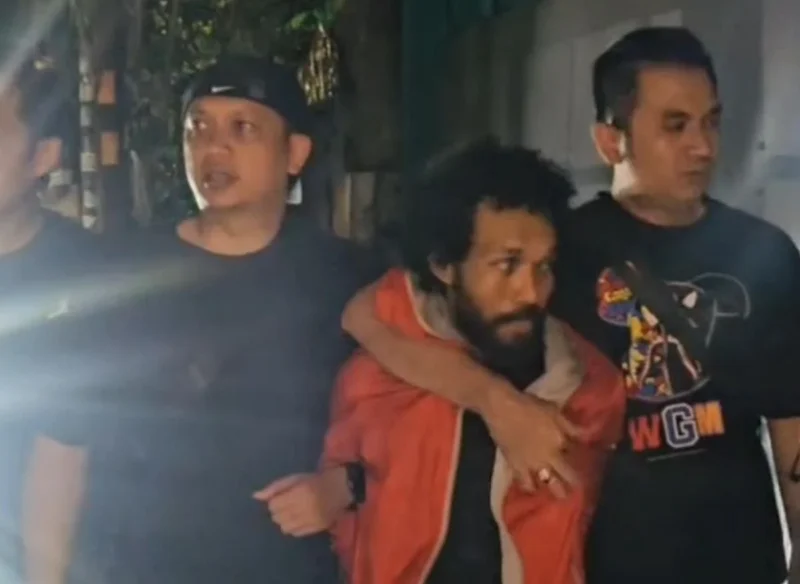 Pelaku penembakan pengacara di Tanah Abang, HD (37), saat dibekuk Tim Jatanras Polda Metro Jaya dan digiring ke mobil polisi. (PMJ)