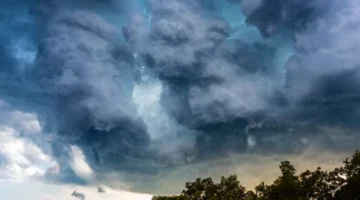 Langit mendung di kawasan Jakarta dengan awan tebal sebagai tanda potensi hujan berdasarkan prakiraan BMKG di wilayah Jabodetabek.
(Posnews/Canva)