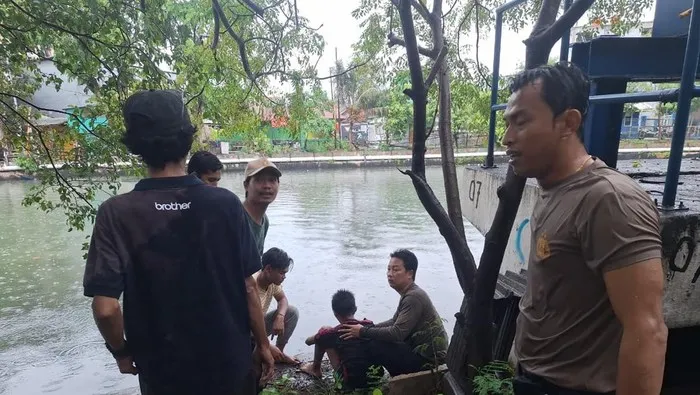 Polisi Bhabinkamtibmas Aipda Elly Ependi menolong remaja yang terseret arus Kali Sindang di Koja. (Posnews/Ist)