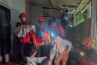 Petugas BPBD membantu warga mengungsi setelah banjir merendam pemukiman di Desa Sukamanah, Jonggol, Bogor akibat tanggul Sungai Cipatujah jebol. (BPBD)