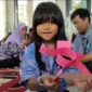 Aisha Salsabila menunjukkan hasil bermainnya dengan Ayahnya di Ruang Kelas B5 TKN Semper Cilincing Jakarta Utara. (Posnews/MR)

