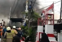 Petugas pemadam kebakaran memadamkan api yang melahap puluhan rumah di Jatipulo, Palmerah, Jakarta Barat. (Posnews/Ist)