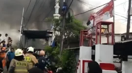 Petugas pemadam kebakaran memadamkan api yang melahap puluhan rumah di Jatipulo, Palmerah, Jakarta Barat. (Posnews/Ist)