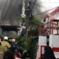 Petugas pemadam kebakaran memadamkan api yang melahap puluhan rumah di Jatipulo, Palmerah, Jakarta Barat. (Posnews/Ist)