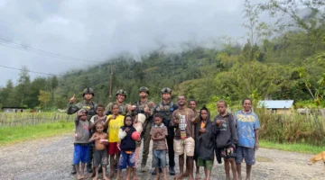 Personel Ops Damai Cartenz bermain dan berfoto bersama anak-anak di Distrik Bibida, Kabupaten Paniai, Papua. (Posnews/Ist)