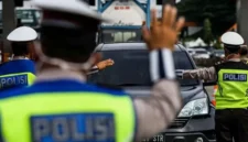 Petugas kepolisian mengatur lalu lintas saat massa buruh turun ke jalan. (Posnews/Net)
