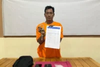 Polisi menggiring tersangka Jamroni, pelaku pemerasan dengan modus mengaku anggota BNN di Pelalawan, Riau. (Posnews/Polsek Pelalawan)