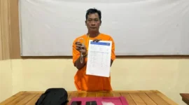Polisi menggiring tersangka Jamroni, pelaku pemerasan dengan modus mengaku anggota BNN di Pelalawan, Riau. (Posnews/Polsek Pelalawan)