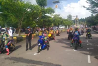 Pembalap bertarung di lintasan road race Buru Selatan dengan ribuan penonton memadati area. (MR/Posnews)