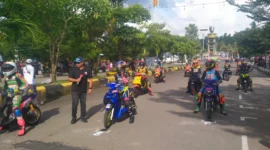 Pembalap bertarung di lintasan road race Buru Selatan dengan ribuan penonton memadati area. (MR/Posnews)