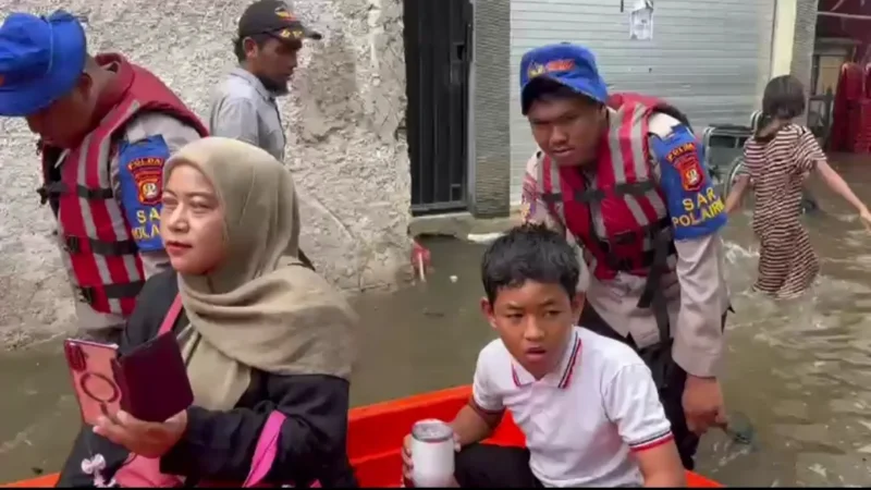 Tim SAR Ditpolairud Polda Metro Jaya mengevakuasi warga menggunakan perahu karet di kawasan Muara Angke yang terendam banjir rob. (Posnews/Ist)