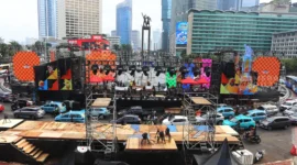 Suasana panggung hiburan malam Tahun Baru 2026 di kawasan Sudirman–Thamrin, Jakarta, dengan keramaian warga dan lampu kota menyala meriah. (Posnews/Net)