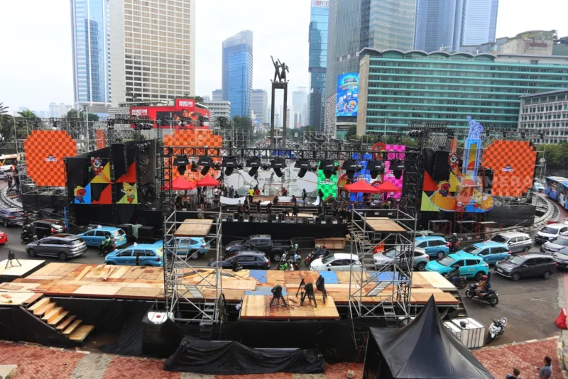 Suasana panggung hiburan malam Tahun Baru 2026 di kawasan Sudirman–Thamrin, Jakarta, dengan keramaian warga dan lampu kota menyala meriah. (Posnews/Net)