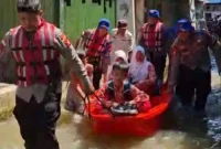 Personel Ditpolairud Polda Metro Jaya mengevakuasi anak sekolah menggunakan perahu saat banjir rob di Kali Adem. (Posnews/Ist)