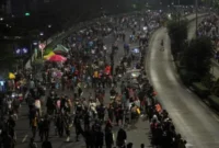 Petugas kepolisian menutup arus lalu lintas di Jalan Sudirman–Thamrin saat penerapan car free night Tahun Baru 2026 di Jakarta. (Posnews/Net)