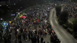 Petugas kepolisian menutup arus lalu lintas di Jalan Sudirman–Thamrin saat penerapan car free night Tahun Baru 2026 di Jakarta. (Posnews/Net)