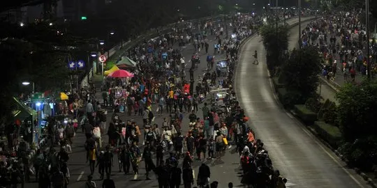 Petugas kepolisian menutup arus lalu lintas di Jalan Sudirman–Thamrin saat penerapan car free night Tahun Baru 2026 di Jakarta. (Posnews/Net)