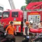 Petugas damkar menembakkan air ke gedung terbakar di Cempaka Baru, Kemayoran, Jakarta Pusat. (Posnews/BPBD DKI)