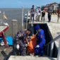 Petugas mengevakuasi jenazah yang ditemukan mengapung di Perairan Rohil, Riau. (Posnews/Ist)