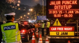 Petugas polisi menutup jalur menuju Kawasan Puncak di Tugu Lampu Gentur Cianjur saat malam pergantian Tahun Baru 2026 untuk mengantisipasi kemacetan. (Posnews/Humas Polda Jabar)